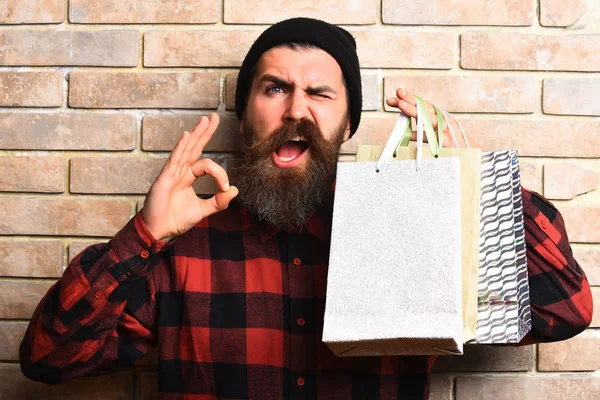 Bärtiger brutaler kaukasischer Hipster mit Schnurrbart hält Einkaufspakete in der Hand — Stockfoto