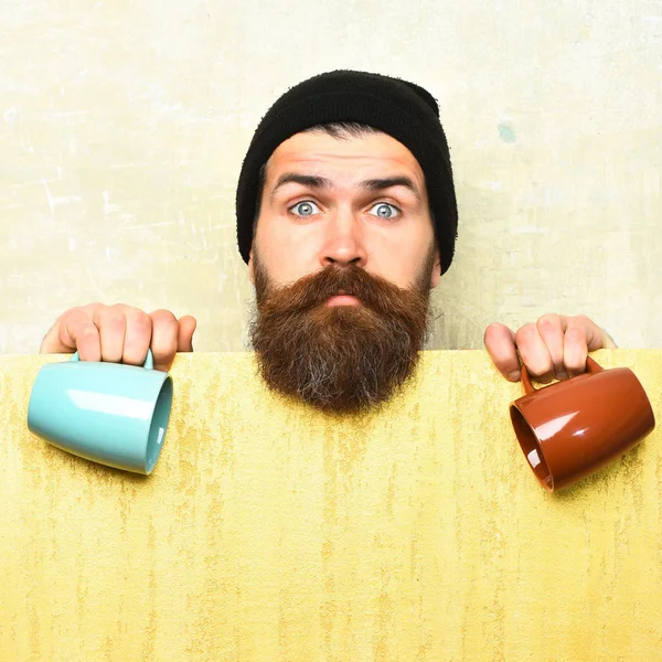 Бородатый брутальный кавказский хипстер с бумажным листом и чашками — стоковое фото