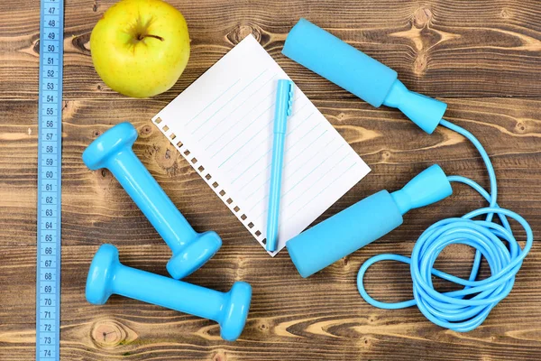 Diet concept with notebook, skipping rope and dumbbells — Stock Photo, Image