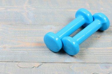 spor salonu ekipman kavramı, mavi dumbbells gri vintage ahşap üzerinde