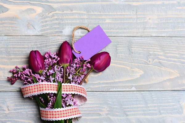 Flores de tulipán y lila con cinta a cuadros y etiqueta púrpura — Foto de Stock