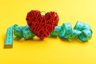 Kıvrılmış ve kırmızı dekoratif kalp bağlı teyp ölçme
