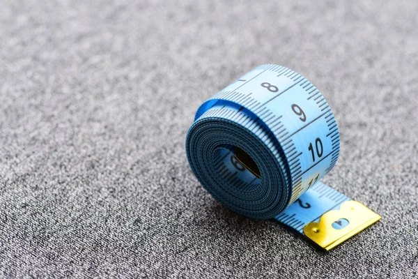 Tejp för att mäta rullade på grå bakgrund — Stockfoto