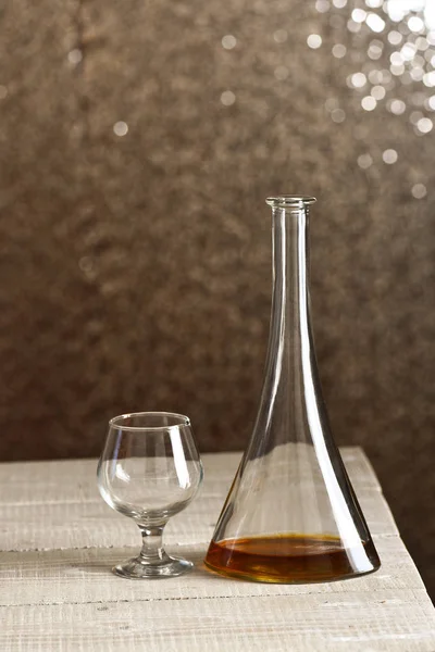 Garrafa com uísque dentro, ao lado de vidro vazio — Fotografia de Stock