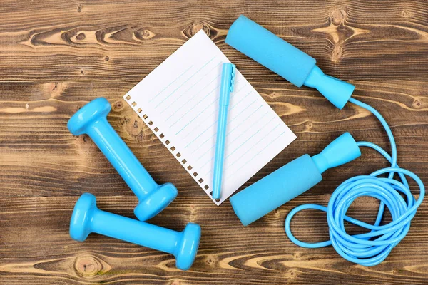Training concept with notebook, skipping rope and dumbbells — Stock Photo, Image