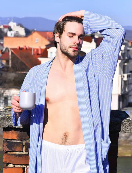 Caucásico macho en azul rayas pijama celebración taza — Foto de Stock