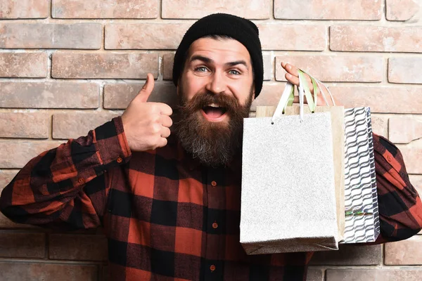 Bärtiger brutaler kaukasischer Hipster mit Schnurrbart hält Einkaufspakete in der Hand — Stockfoto