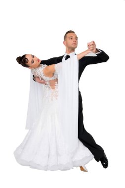 Dans eden balo çifti beyaz sahilde yalnız poz veriyor.