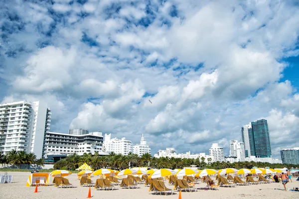Playa con tumbonas bajo sombrillas amarillas — Foto de Stock