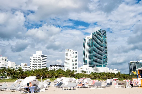 İnsanlar altında gri şemsiye plajda şezlong üzerinde rahatlatıcı — Stok fotoğraf