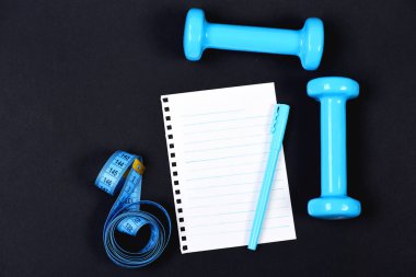 Bant, mavi dumbell ve kalem boş defter sayfası ile ölçme
