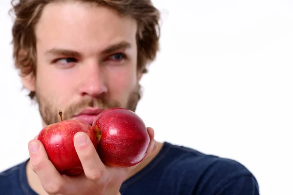 Manzanas en color rojo y hombre barbudo sexy mirando a un lado — Foto de Stock