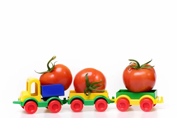 Concepto de importación, tomates rojos en plástico camión coche juguete — Foto de Stock