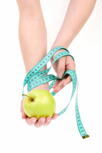 Tape for measuring wraps around female hands with apple Stock Image