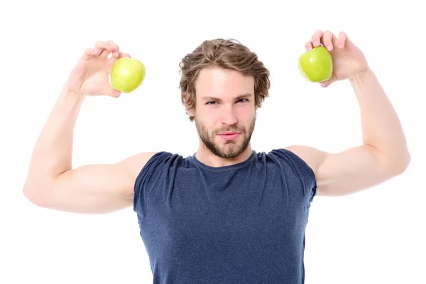 Macho con fuerte expresión facial y músculos sosteniendo manzanas verdes — Foto de Stock