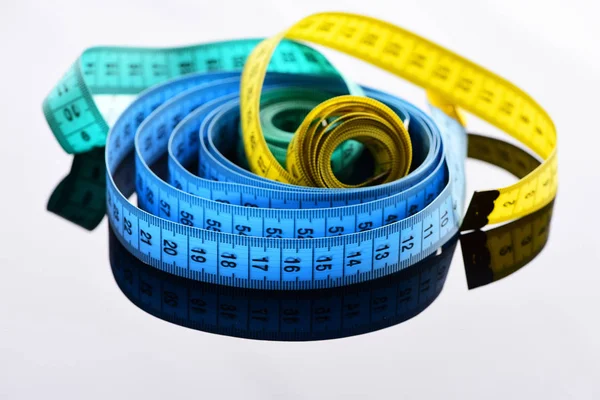 Rollos de medidas de cinta de colores en la superficie gris con reflexión — Foto de Stock