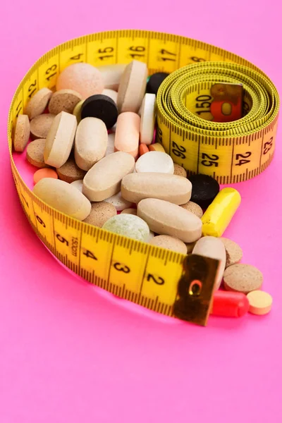 Concepto de salud, dieta y calorías: cinta métrica y pastillas — Foto de Stock