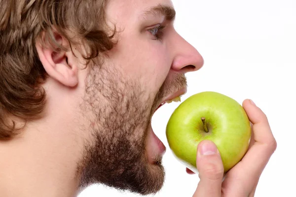 Chico tratando de morder gran manzana verde mirándolo —  Fotos de Stock