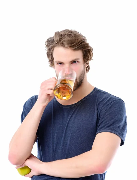Hombre con mirada sexy bebe cerveza y sostiene manzana verde — Foto de Stock