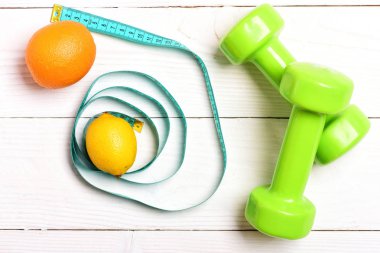 Limon ve portakal meyve mavi bant dumbbells yakınındaki ölçme