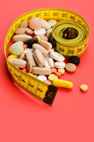 Рулон желтой ленты для измерения и различных таблеток — стоковое фото