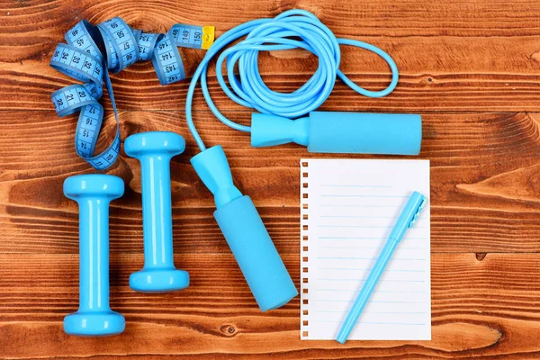 Spor programı kavramı ile defter, atlama ipi ve halter, santimetre