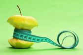 Flexibilní vládce v azurové barvě obtéká kolem pokousaný apple