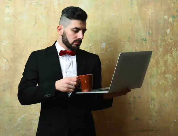 Bearded project manager met serieus gezicht zet koffie op laptop — Stockfoto