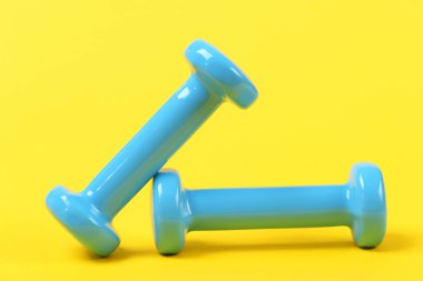 İki dambıl Sarı zemin üzerine mavi renkte