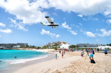 beach observe low flying airplanes landing near Maho Beach clipart