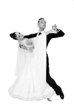 Dans eden balo çifti beyaz sahilde yalnız poz veriyor.