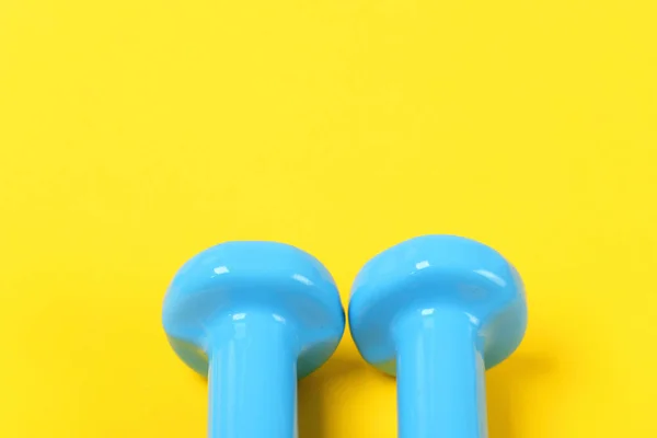 Tops de halteres de peso fixo azul no fundo amarelo — Fotografia de Stock
