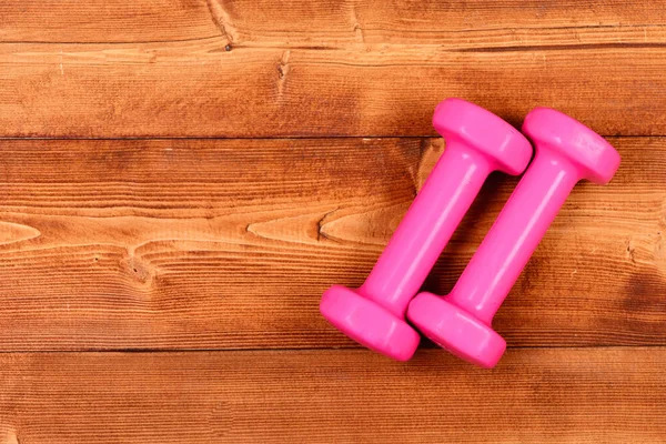 Fitness halteres rosa em marrom vintage — Fotografia de Stock