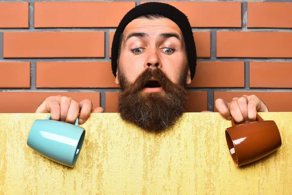 Barbudo brutal hipster caucásico con hoja de papel y tazas —  Fotos de Stock