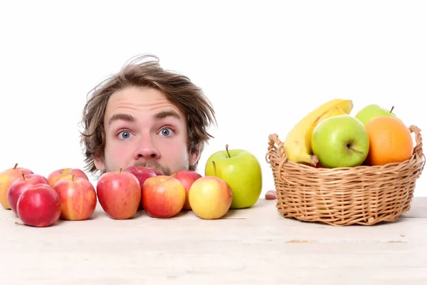 Joven sorprendido y manzanas rojas o verdes — Foto de Stock