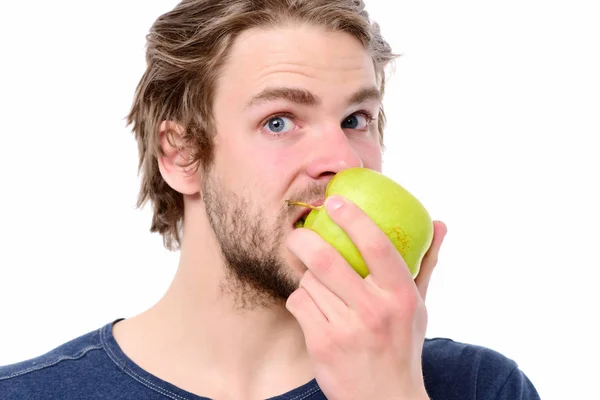 Jovem de tshirt azul mordendo grande maçã verde — Fotografia de Stock