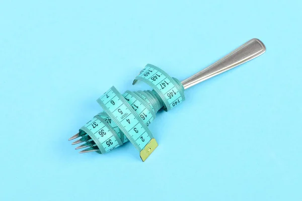 Tape for measuring wrapped around metal fork — Stock Photo, Image