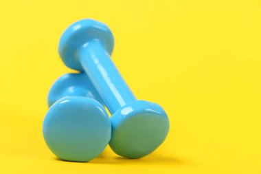 Parlak sarı zemin üzerine plastik dambıl