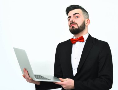 Sakallı meraklı ve gururlu broker beyaz dizüstü bilgisayar tutuyor.