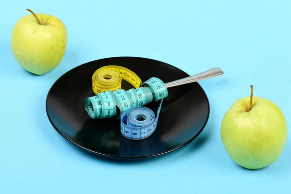 Äpplen och svart keramisk platta med mäta band — Stockfoto