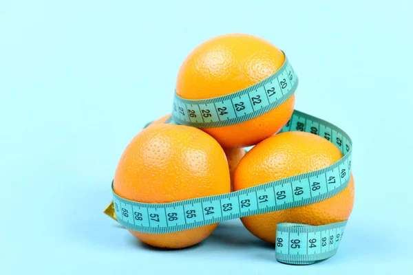 Montón de naranjas envueltas alrededor con cinta cyan para medir — Foto de Stock