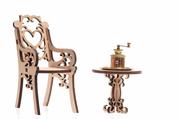 Młynek do kawy zabytkowe na drewnianym stole z krzesłem na białym tle — Zdjęcie stockowe
