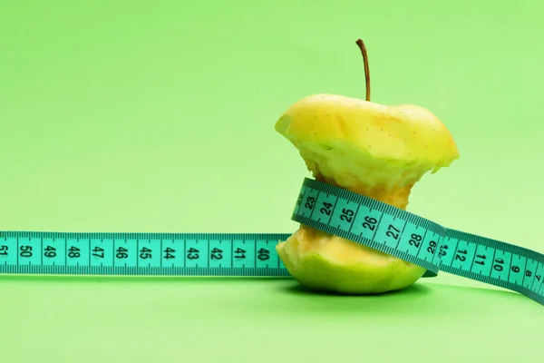 Tejp för mätning i cyan färg band runt bitten äpple — Stockfoto