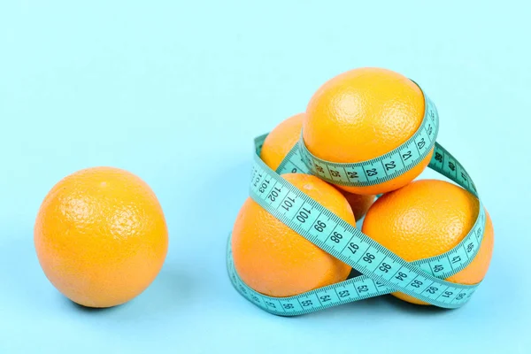 Högen av apelsiner virad runt med cyan flexibel linjal — Stockfoto