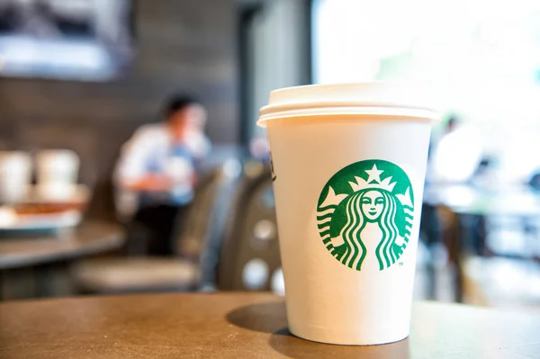 A tall Starbucks coffee cup in starbucks offee shop. — Stock Photo, Image