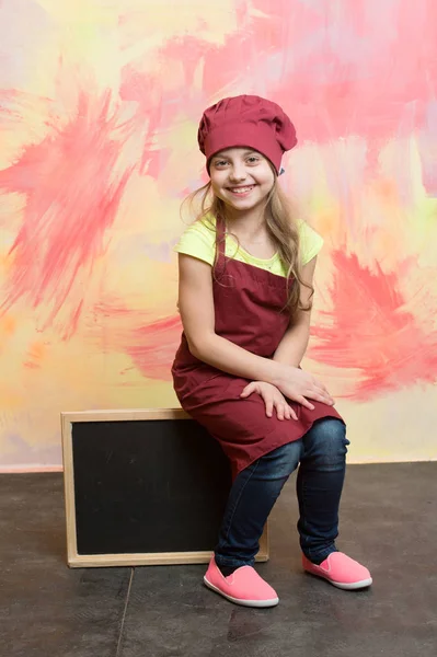 Enfant, fille heureuse cuisinière en chapeau de chef rouge, tablier — Photo