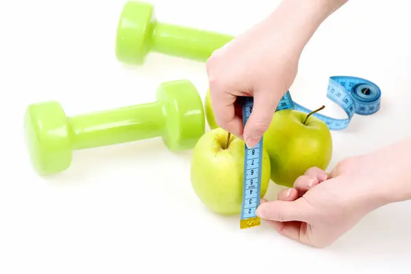 Ruban pour mesurer roulé dans les mains des femmes mesure pommes — Photo