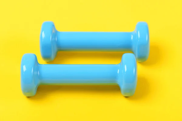 Equipamento de treino e exercício: dois halteres na cor azul claro — Fotografia de Stock