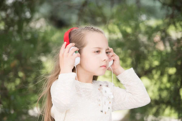 Bonita niña disfrutando de la música usando auriculares — Foto de Stock
