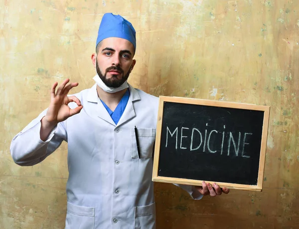 Man in laboratory coat shows ok sign